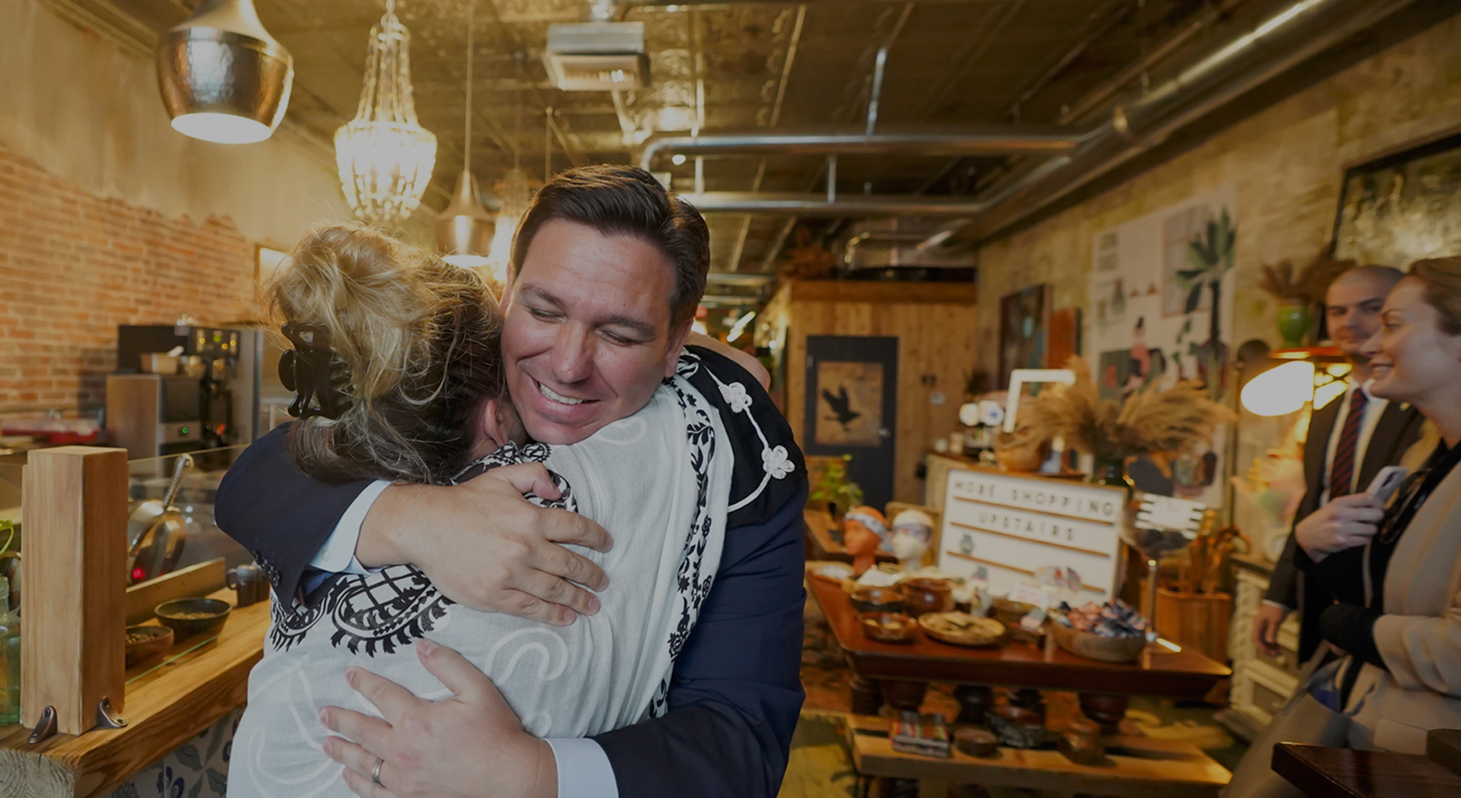 Image of Governor DeSantis hugging a lady inside a building