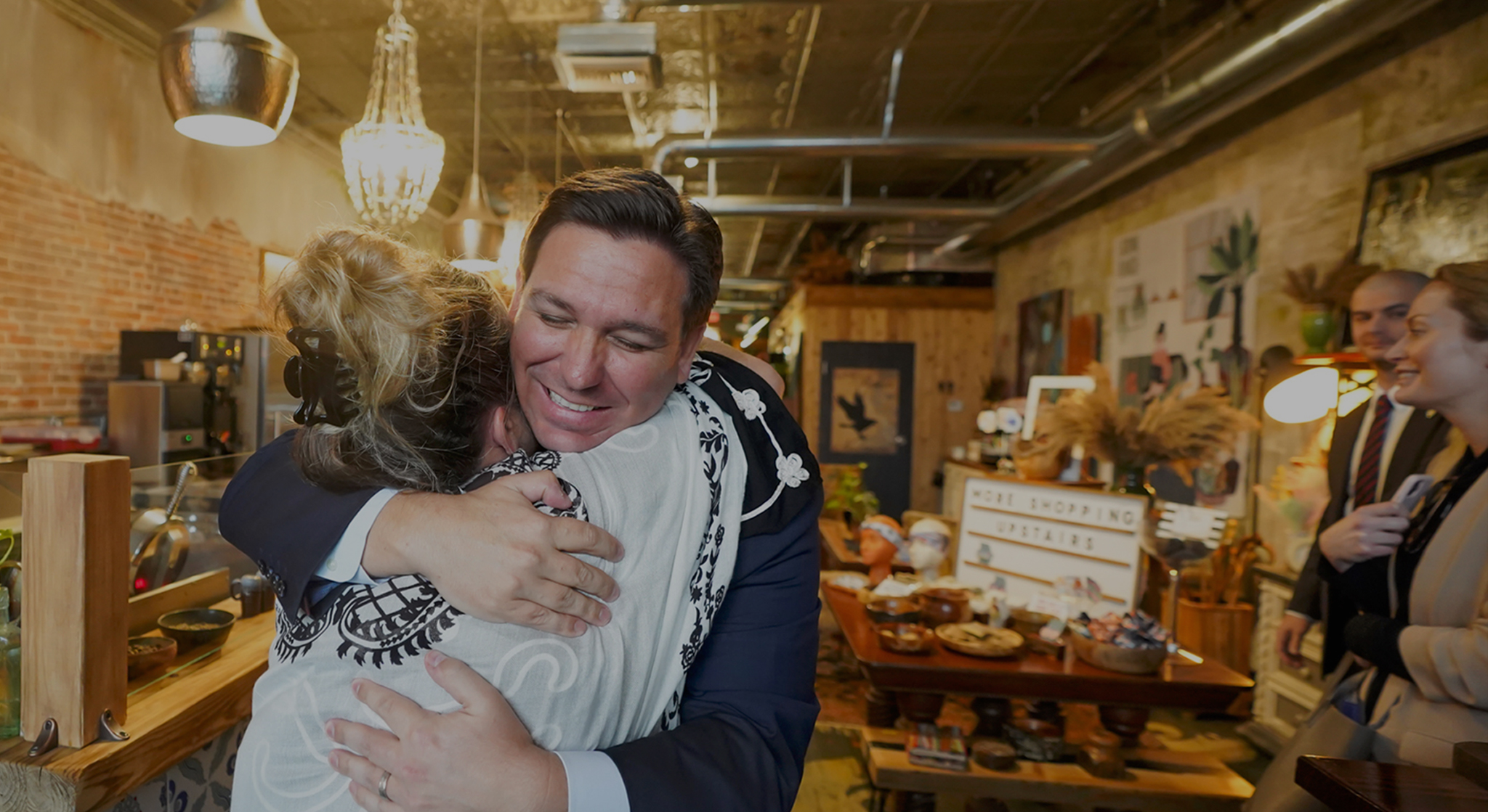 Image of Governor DeSantis hugging a lady inside a building